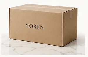 A kraft shipping box printed with the word NOREN, on a marble surface
